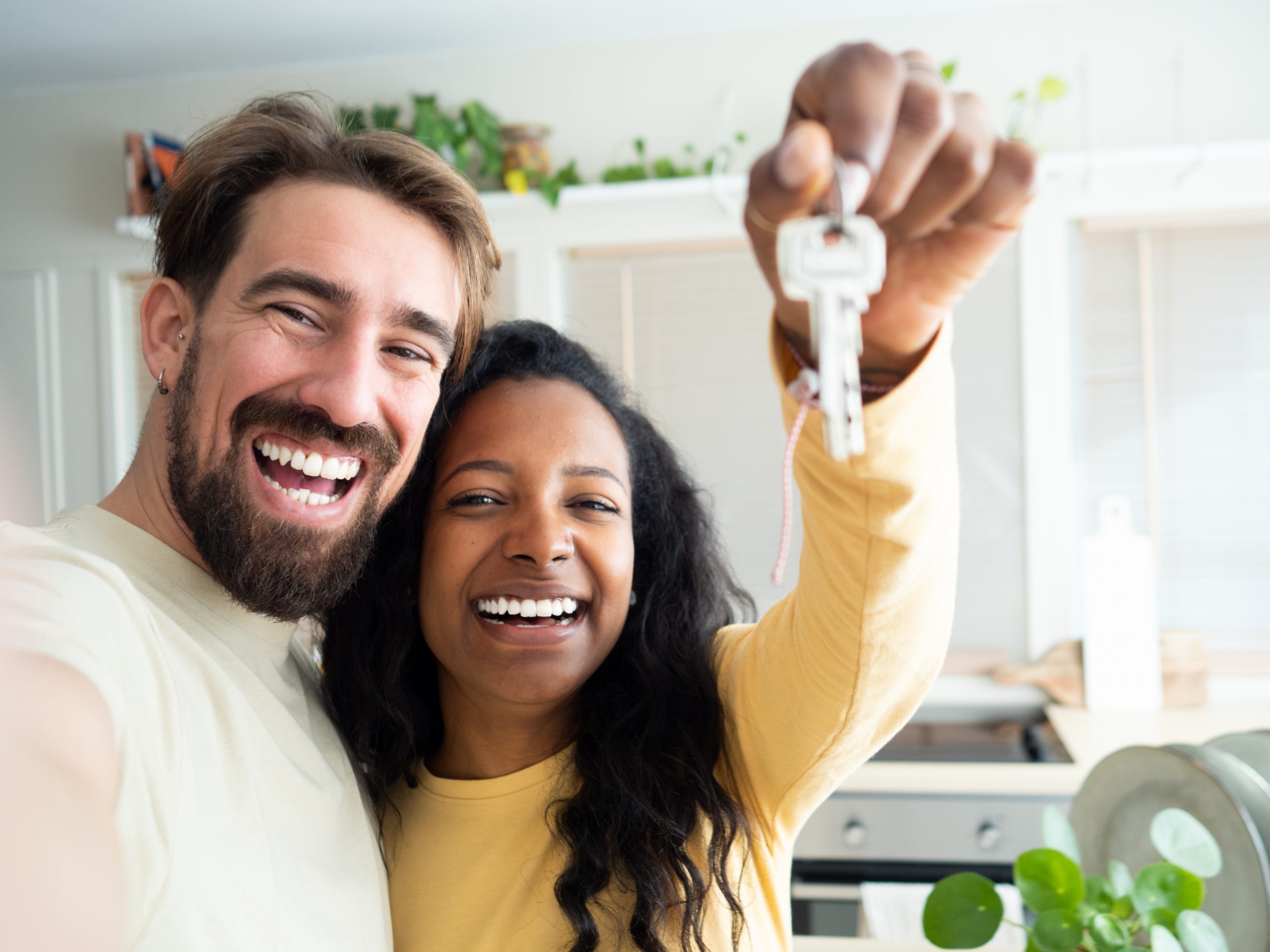POV selfie of Smiling couple show the keys to their new house.